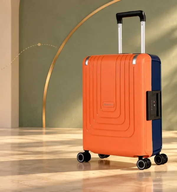 Orange and dark-blue Eminent Vertica suitcase in a cream and sage editorial setting.